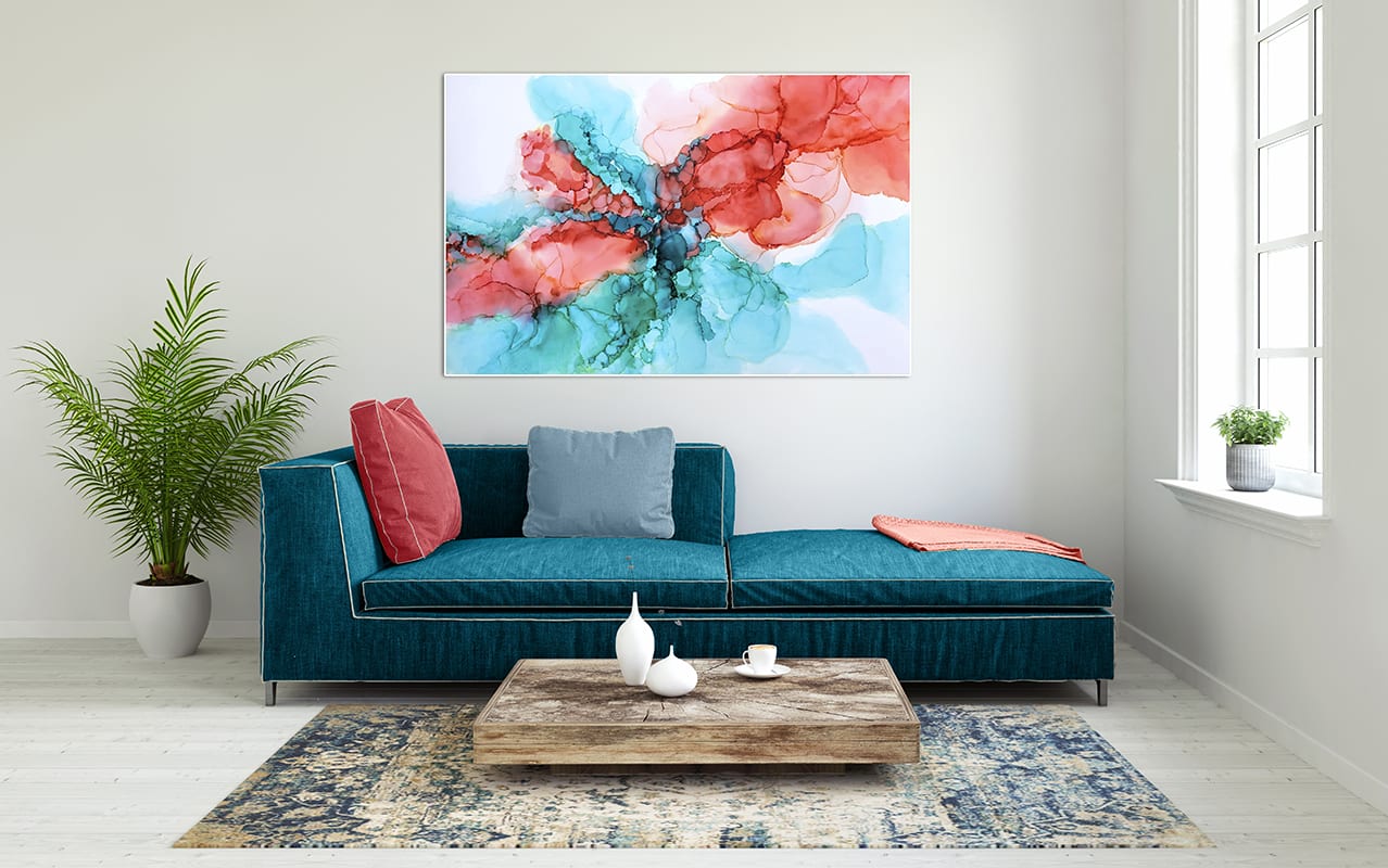 Abstract brightly coloured artwork in turquoise and coral in an elegant living room with a matching blue sofa and coral red cushions